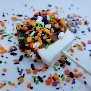 Marshmallow pop dipped in chocolate and sprinkled with Halloween candies